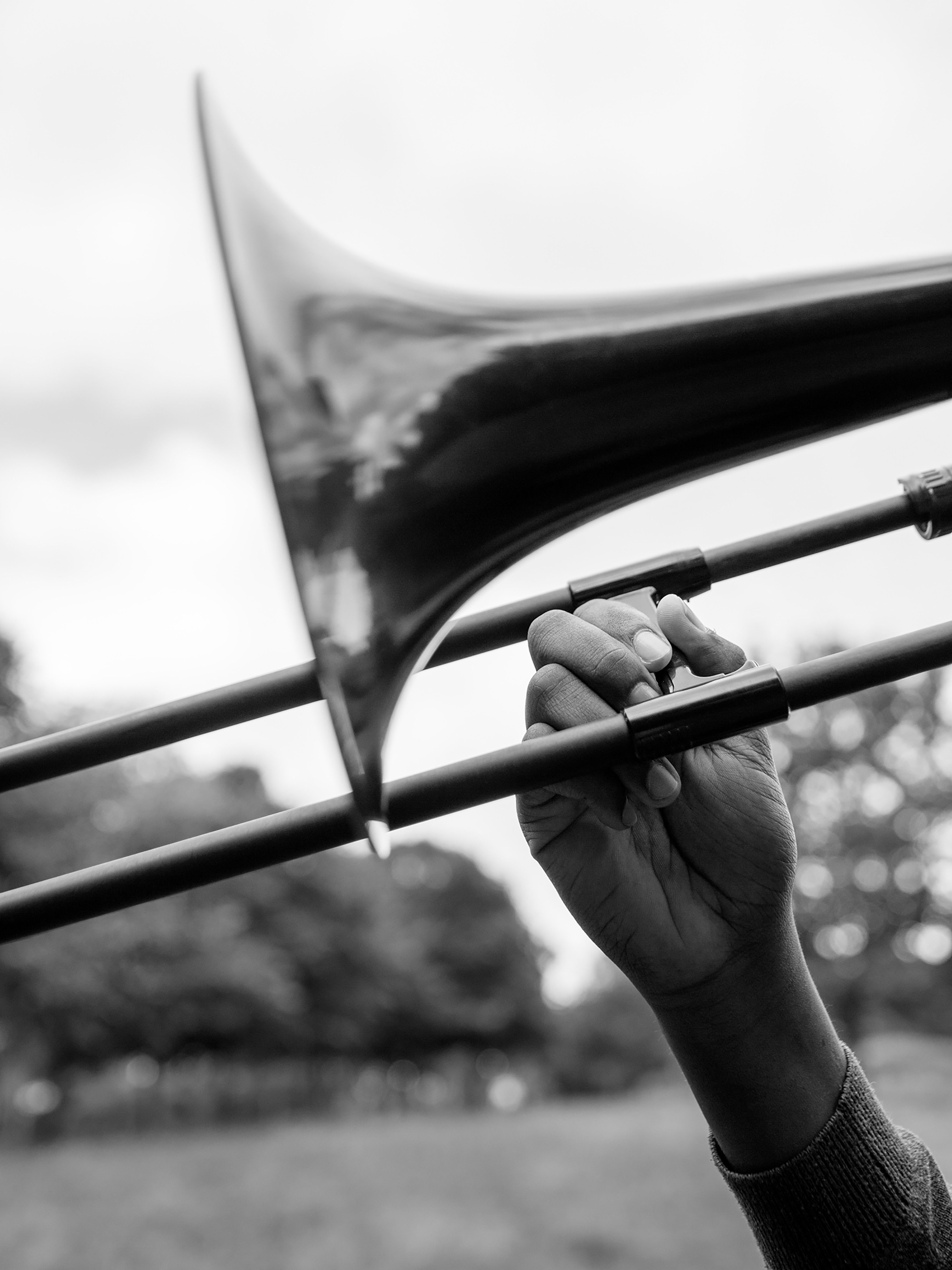 A black and white photograph showing one of the participants playing the trombone